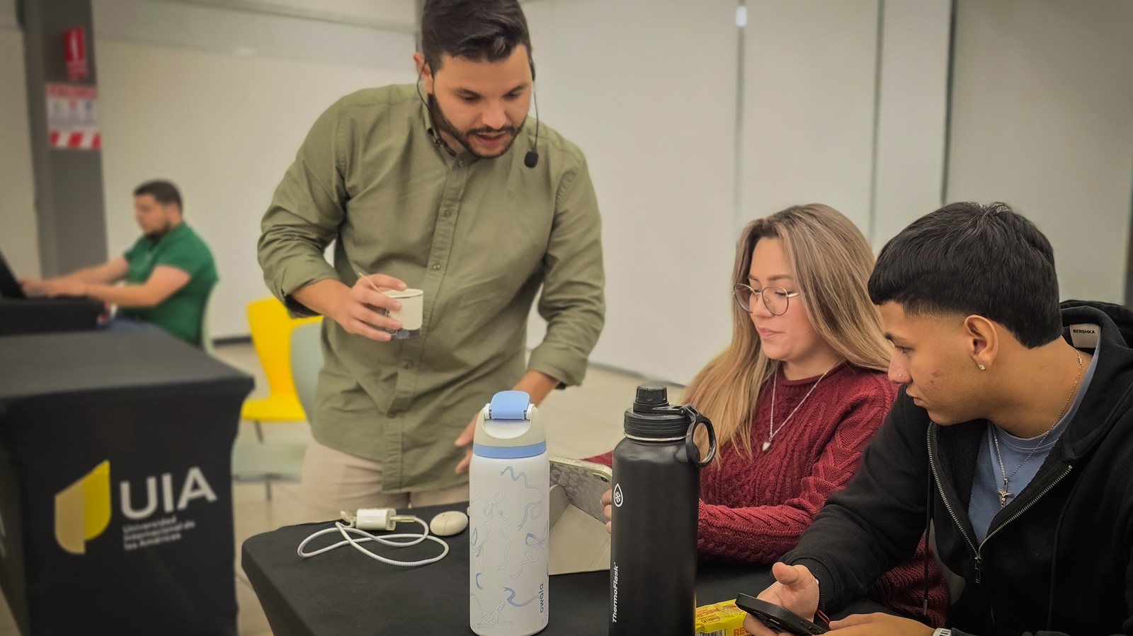Ángel Molina trabajando con dos asistentes en una mesa de trabajo de inteligencia artificial en la Universidad Internacional de las Américas, Costa Rica