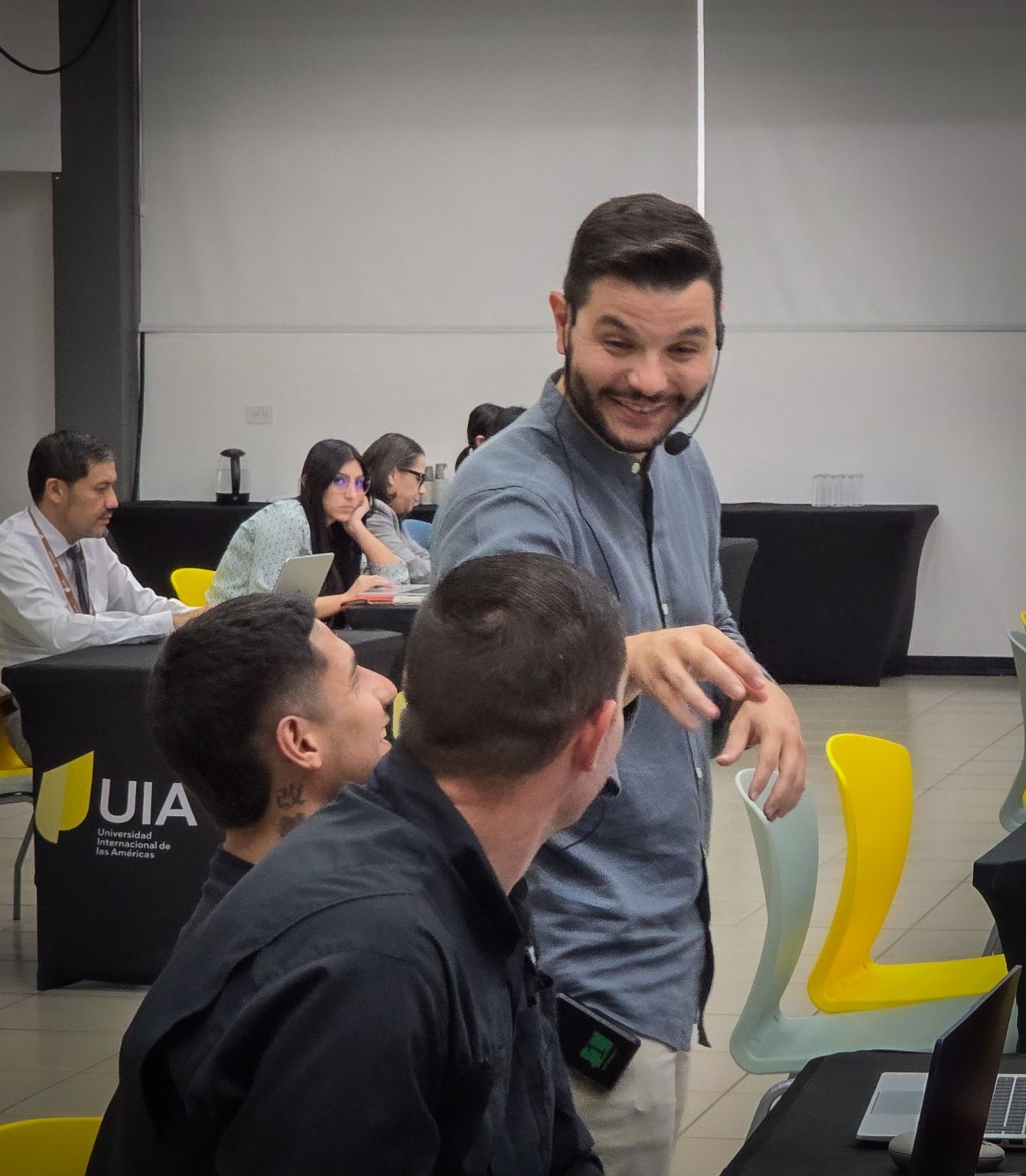 Ángel Molina sonriendo con dos asistentes durante un taller de inteligencia artificial en Costa Rica