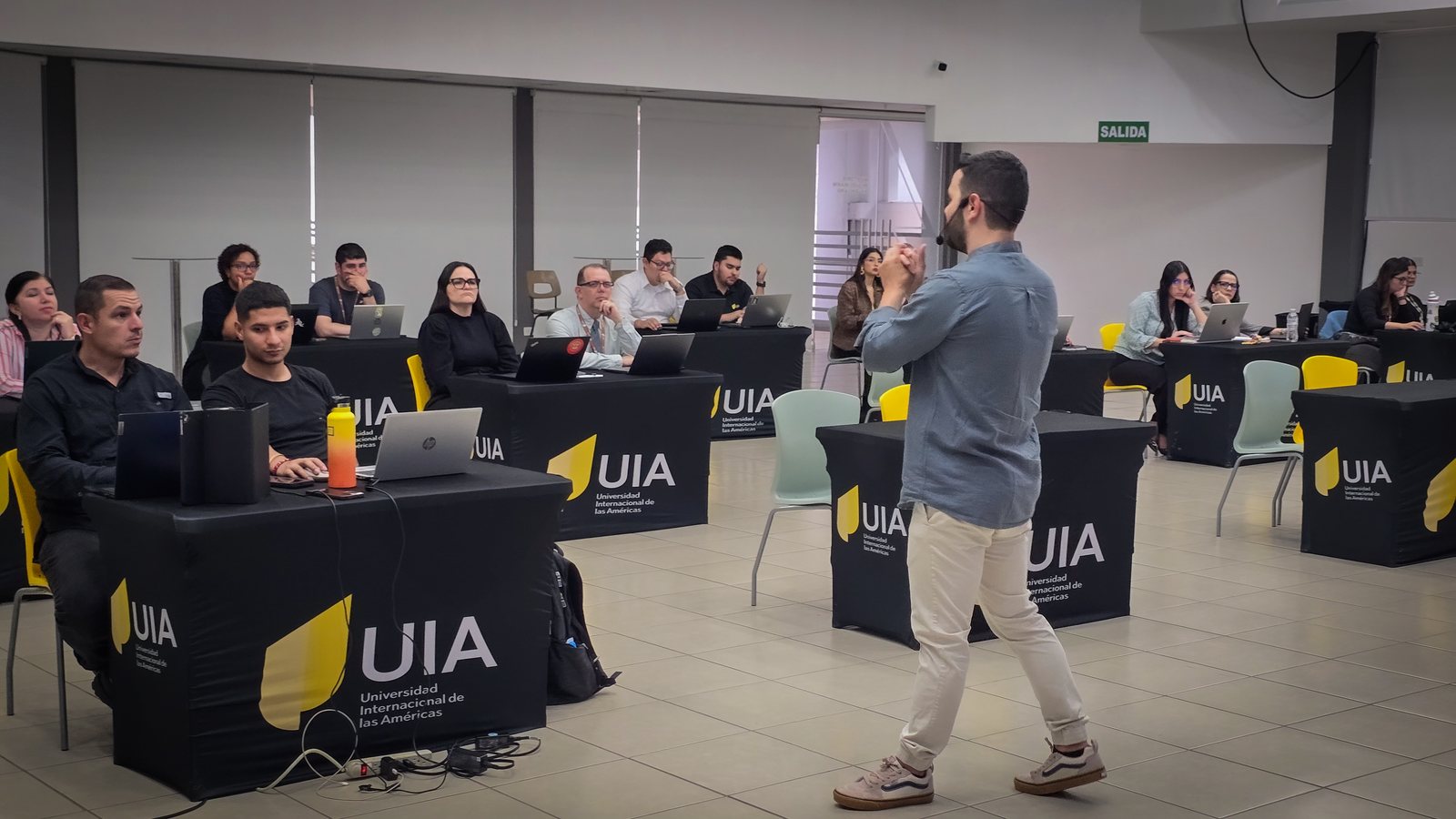 Ángel Molina dirigiendo un taller de inteligencia artificial ante una sala llena en la Universidad Internacional de las Américas, Costa Rica